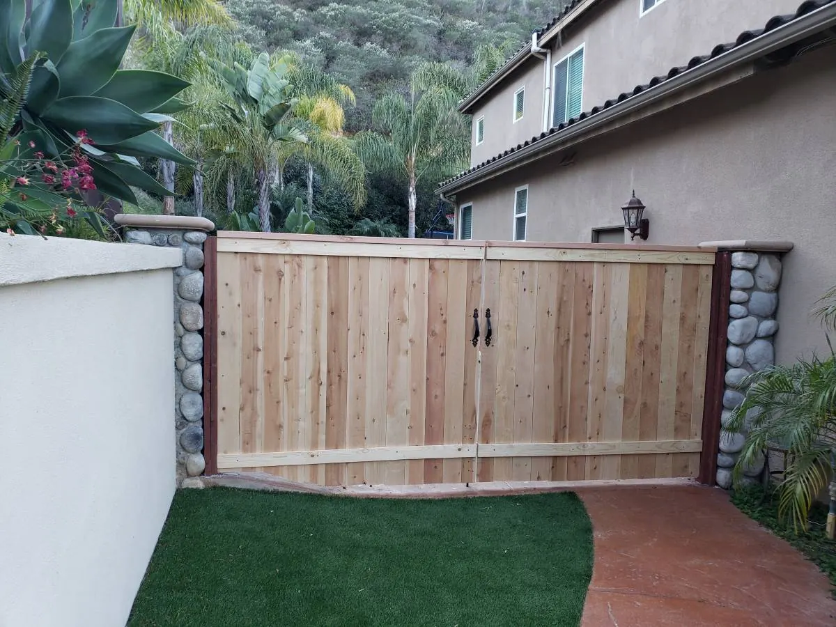 Wood double gate installed between stone pillars